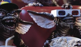 Gremlins sitting in theater seats gawking at the screen