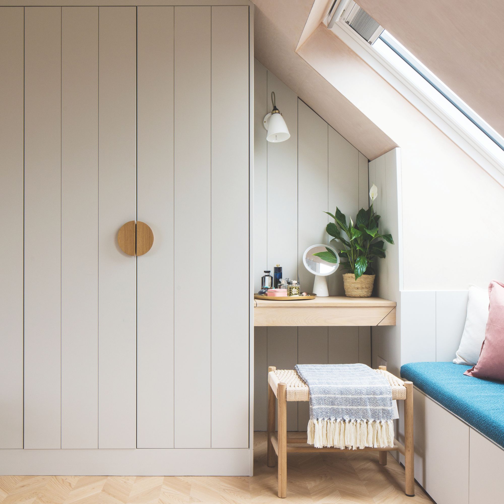 Loft bedroom with fitted wardrobes and a dressing table beside it