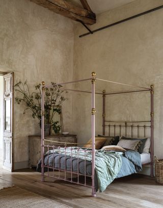 Pink four poster bed with curved top brass rail