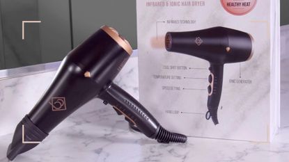 An image of the Boujee Blow Dryer on marble with the box