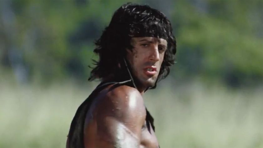 Sylvester Stallone stares into the landscape in his black bandana as enemies approach. 