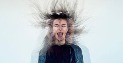 Digital manipulation of a young woman's image tossing her flowing gray long hair