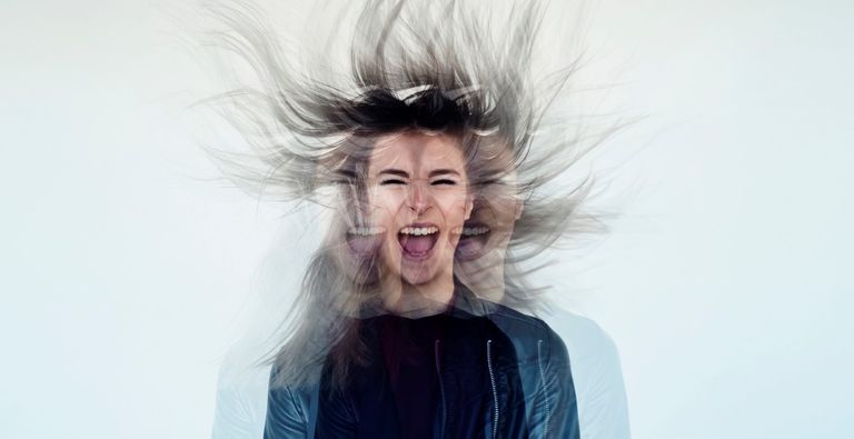 Digital manipulation of a young woman's image tossing her flowing gray long hair