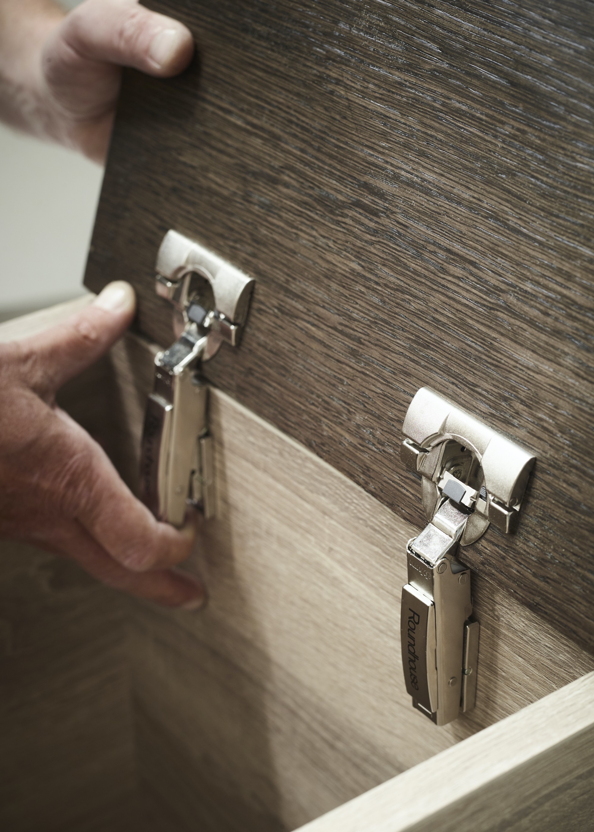 a kitchen cabinet that has been open with two silver hinges locked onto it