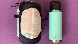 Sea to Summit Ember quilt in stuff sack next to Yeti water bottle