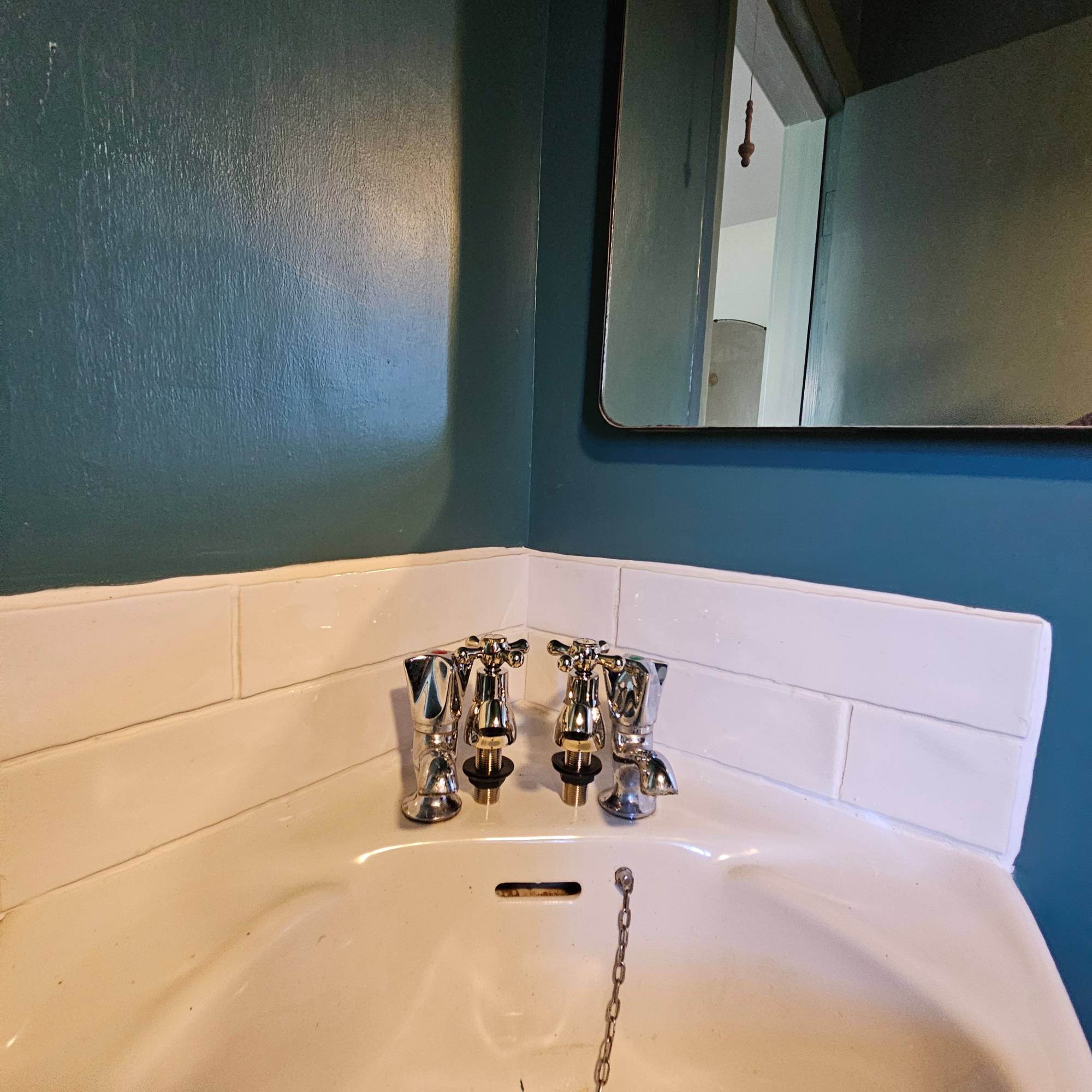 dark blue bathroom with white tiles and sink