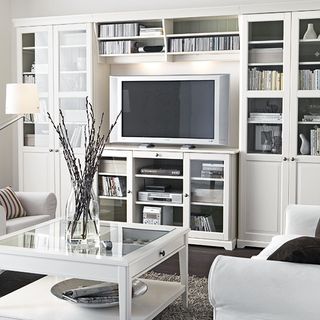 living room with smart tv on wooden desk and white sofa set
