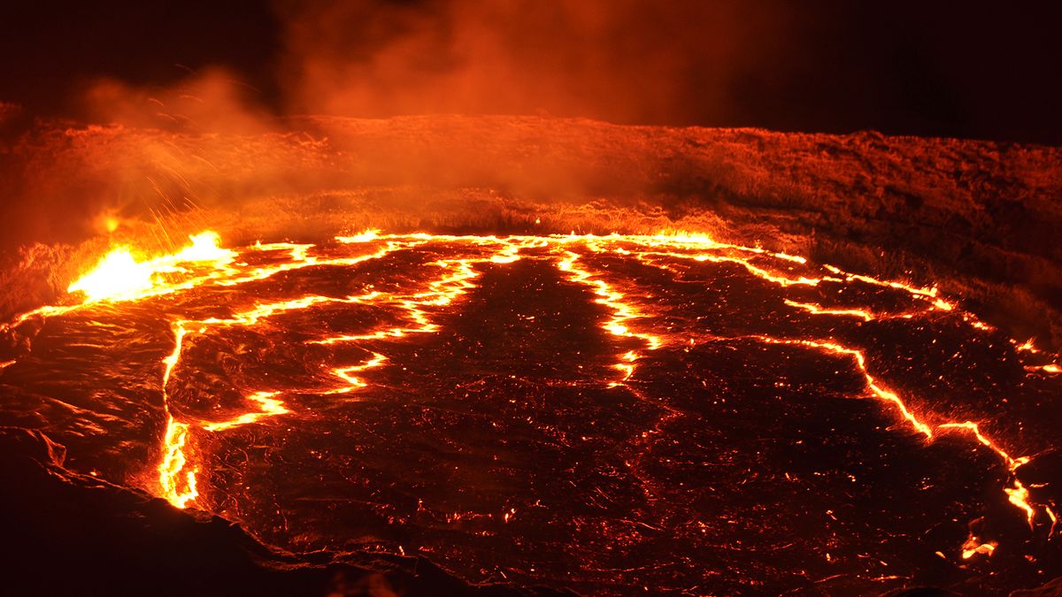 Molten flows glow in a volcano&#039;s lava lake.