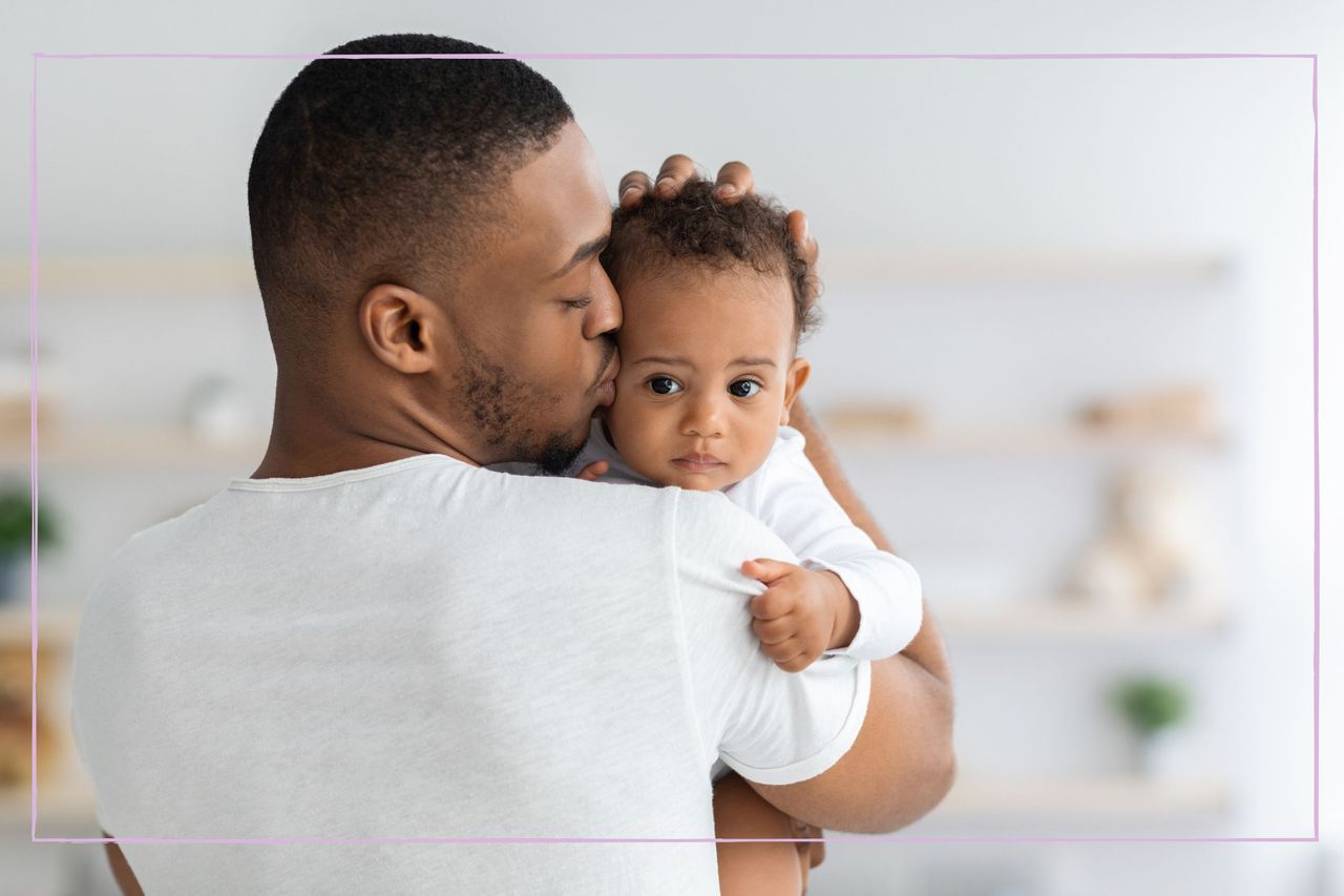 Dad cradling and kissing young baby