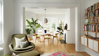 White open-plan living-dining room with oak mid-century dining chairs