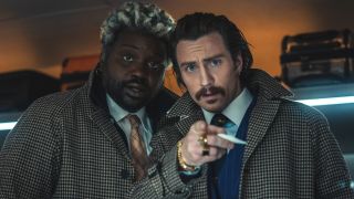 Brian Tyree Henry and Aaron Taylor-Johnson looking surprised at something right in front of them in Bullet Train.