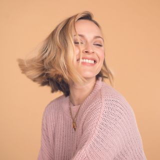 smiling fearne cotton with golden hair and cream walll