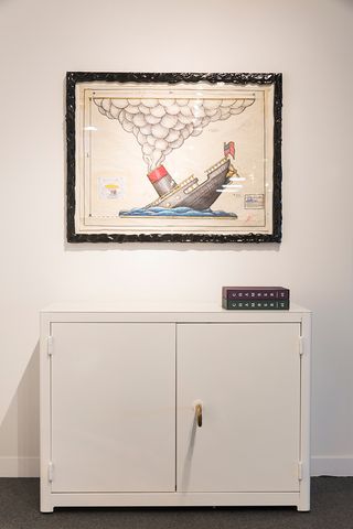 Artist's impression of the sinking of the Titanic, hanging on the wall above a white cupboard