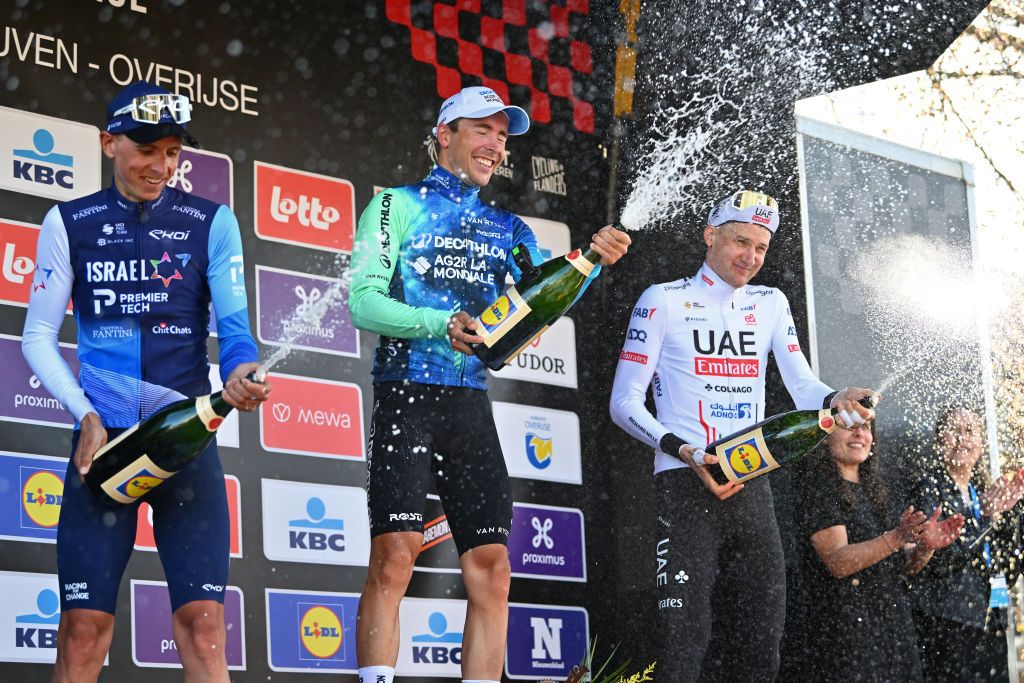 OVERIJSE BELGIUM APRIL 10 LR Dylan Teuns of Belgium and Team Israel Premier Tech on second place race winner Benoit Cosnefroy of France and Decathlon AG2R La Mondiale Team and Tim Wellens of Belgium and UAE Team Emirates on third place pose and celebrate with champagne on the podium ceremony after the 64th De Brabantse Pijl La Fleche Brabanconne 2024 Mens Elite a 1952km one day race from Leuven to Overijse on April 10 2024 in Overijse Belgium Photo by Luc ClaessenGetty Images