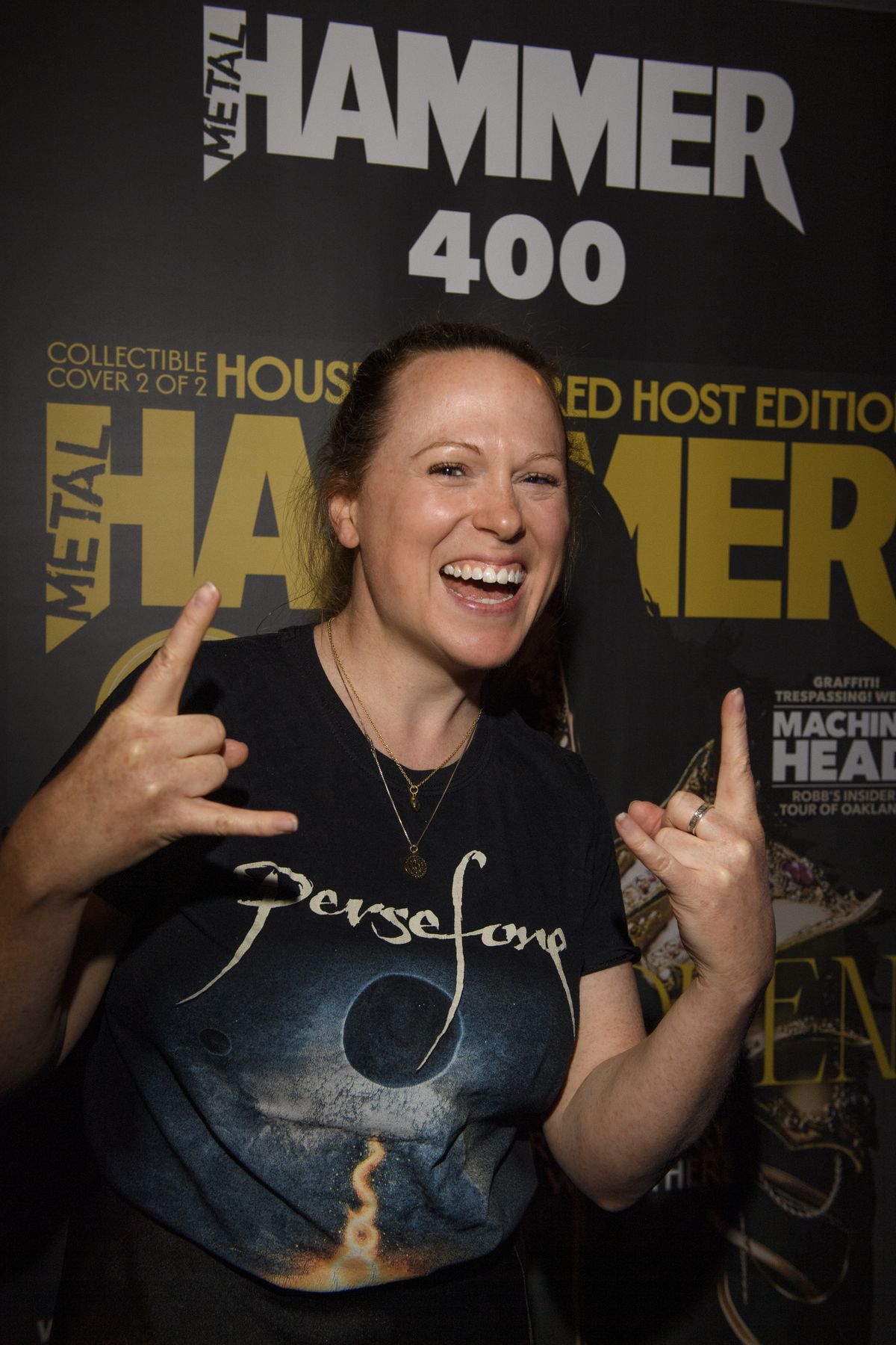 A woman throwing horns