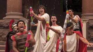 Fraternity brothers with water toys having fun in Amazon Prime's Overcompensating Season 1.