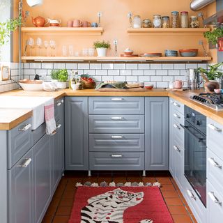grey kitchen with orange painted walls