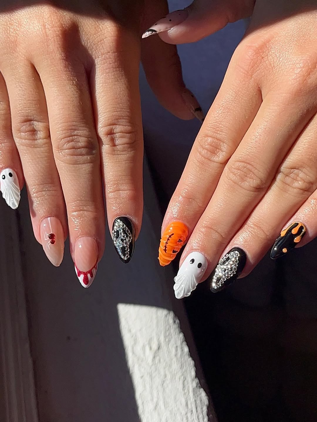 halloween nail art with ghosts, pumpkines, and vampire designs