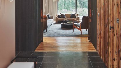 entrance hall leading into living room with sliding doors and rustic wood panelling