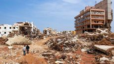 Two men amid ruined buildings, in the aftermath of flooding in Libya