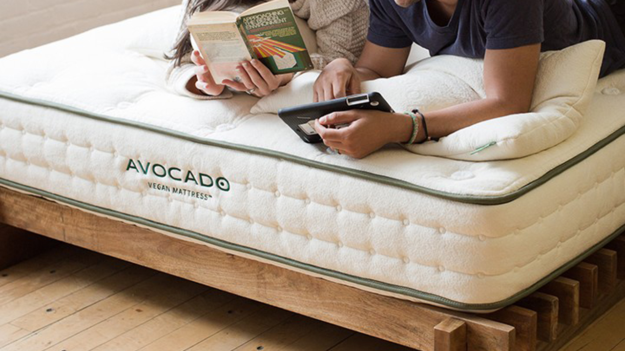 Avocado mattress sales, discounts and promo codes: a couple read books while lying on the Avocado Green Mattress