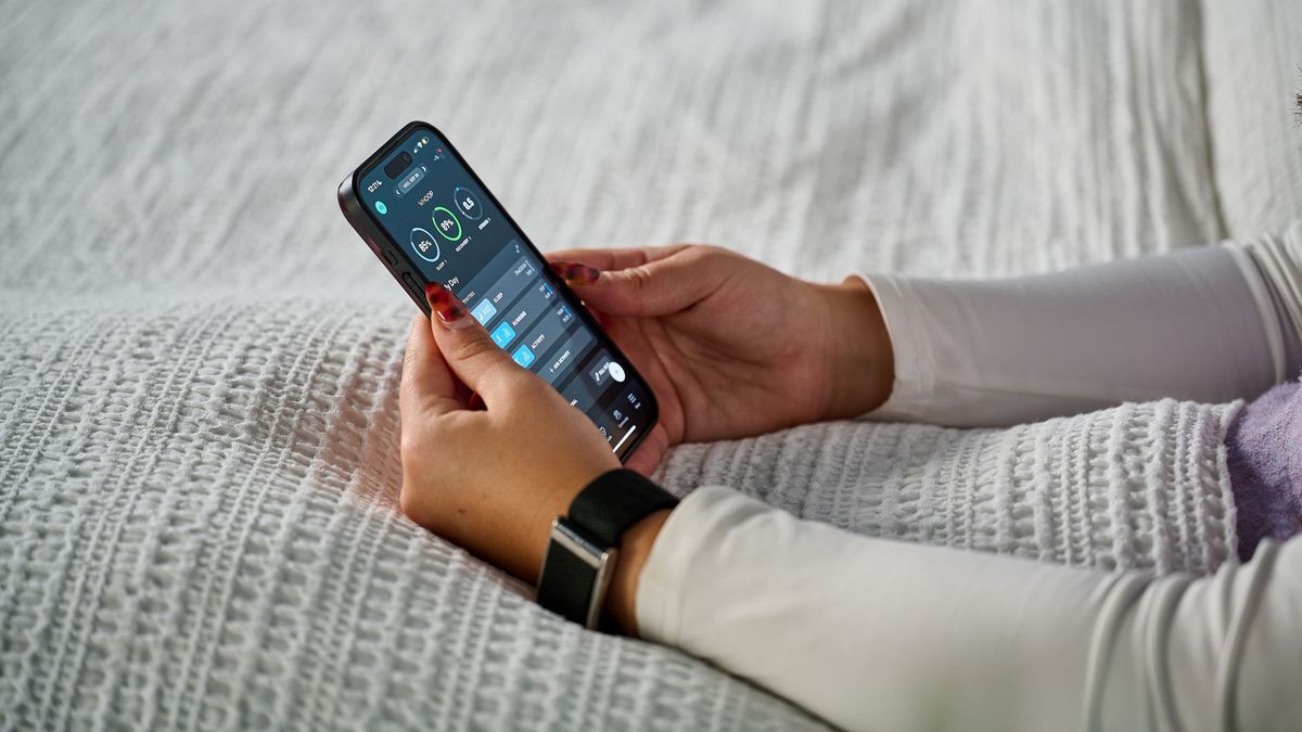 Tom's Guide's sleep tech tester checking sleep and recovery scores on the Whoop app in bed wearing the Whoop MG on left wrist