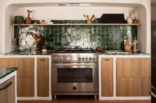 A kitchen backsplash in dark green tiles