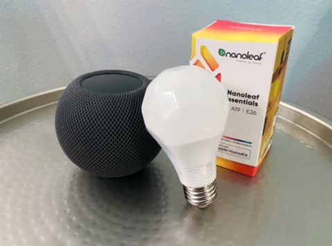Nanoleaf Essentials A19 Light Bulb and Packaging next to a HomePod mini
