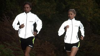 Man and woman running in reflective Proviz jackets