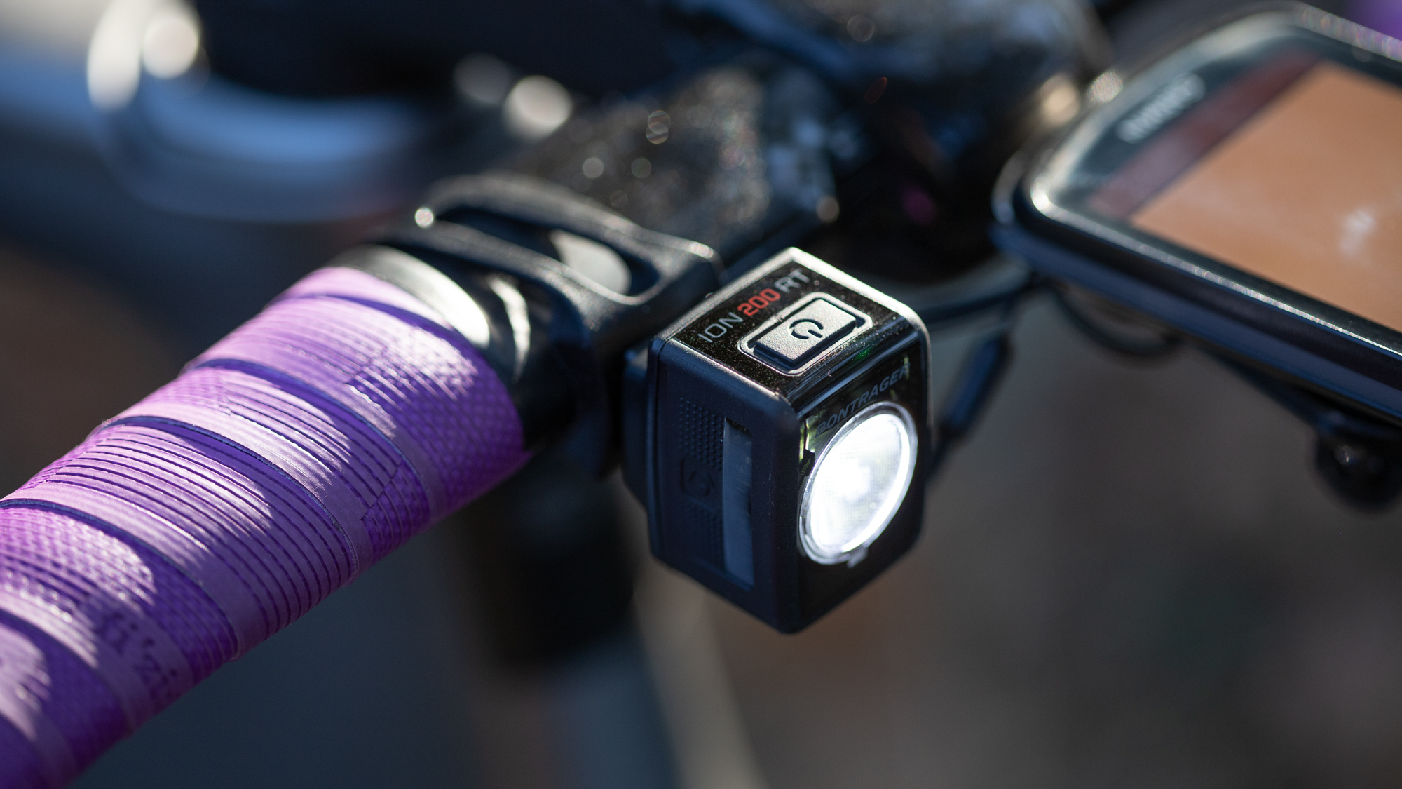 Bontrager Ion 200 RT front bike light fitted to a handlebar with purple bar tape