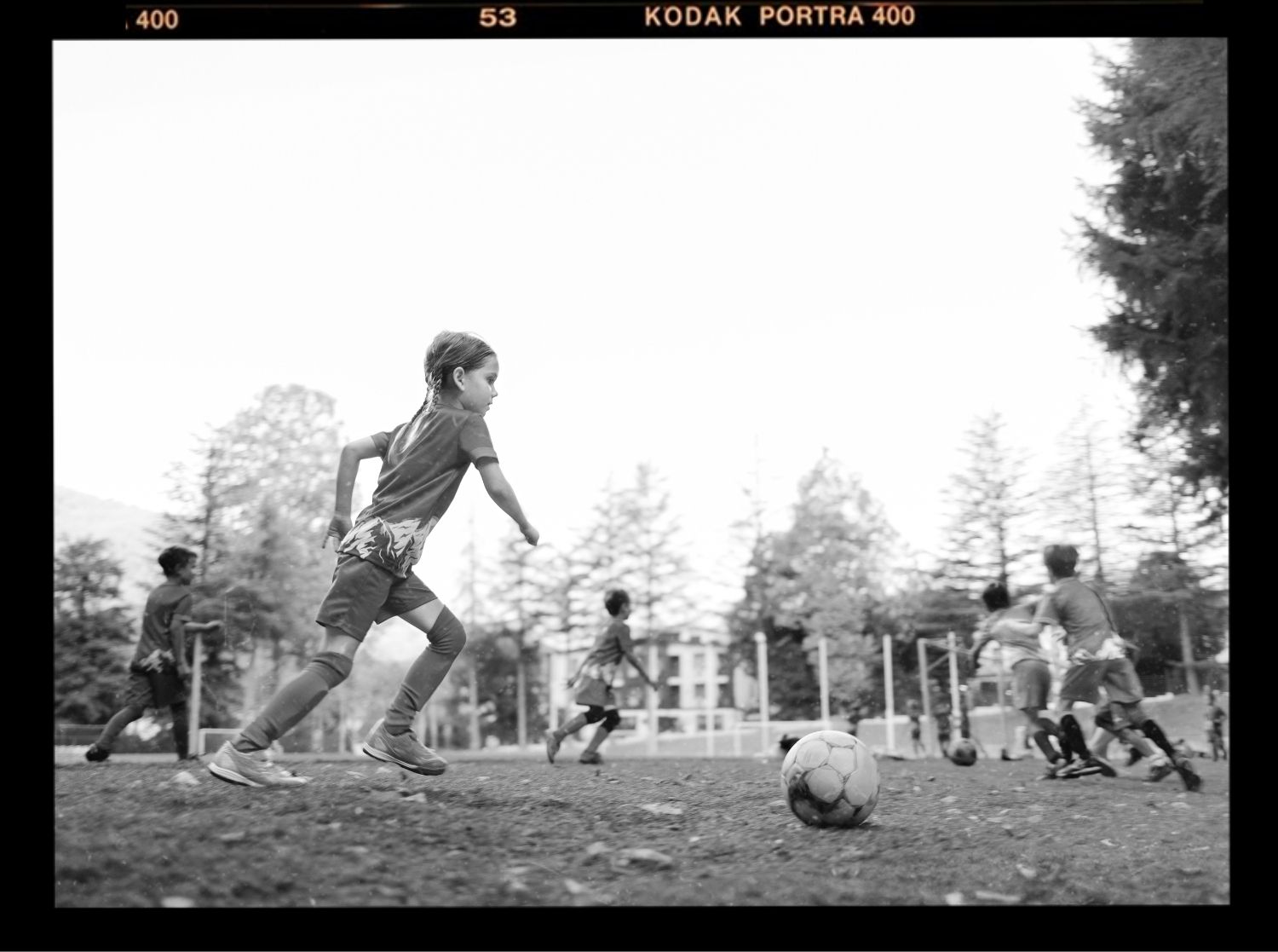 Young girls playing a variety of different sports: football, rollerblading, basketball, rock climbing and swimming