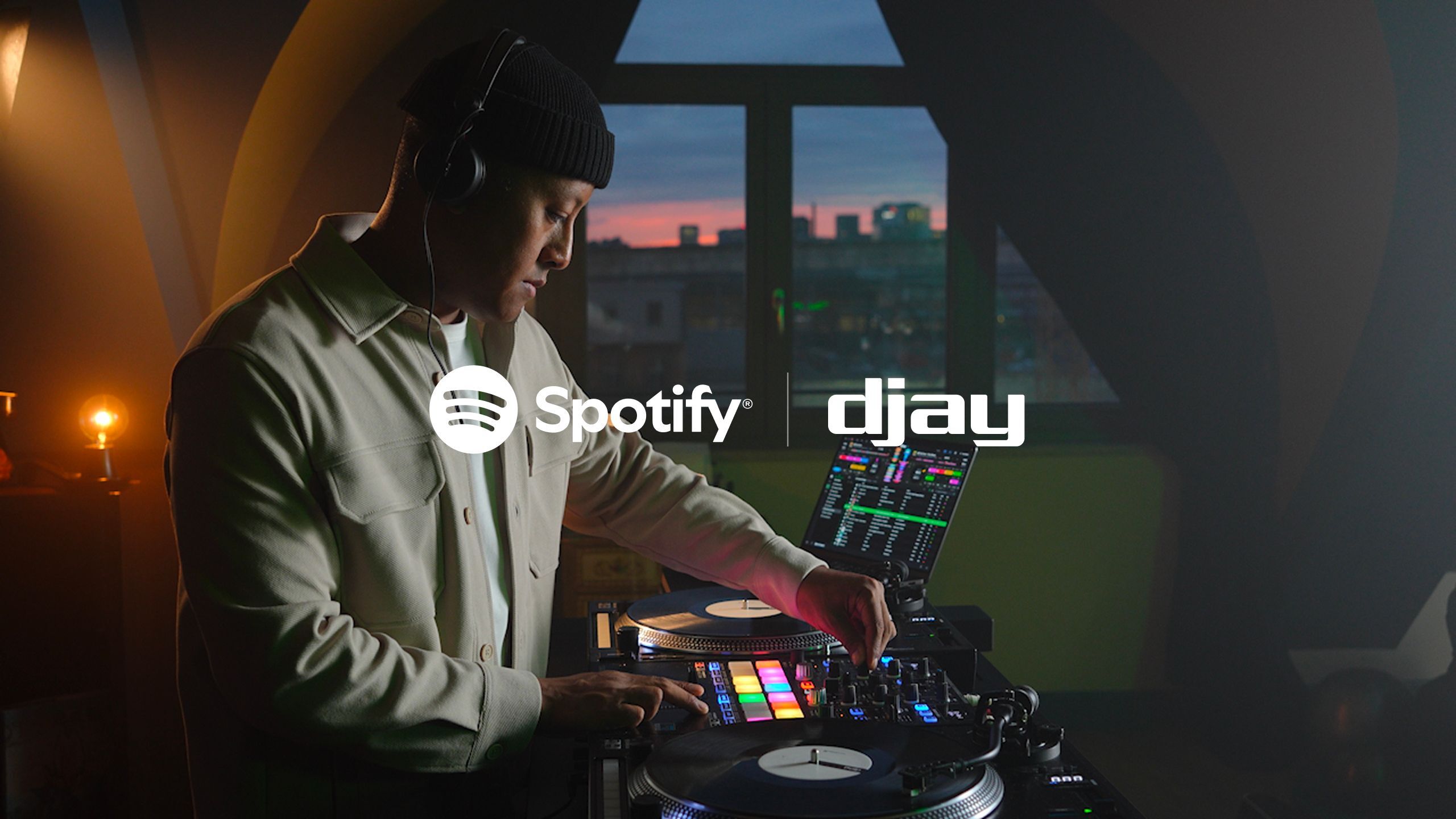 A promotional image celebrating the launch of Spotify integration in the djay app.