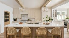 A neutral coastal kitchen with woven counter stools and wood accents