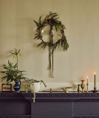 Wreaths on the wall above the fireplace, decorated mantel