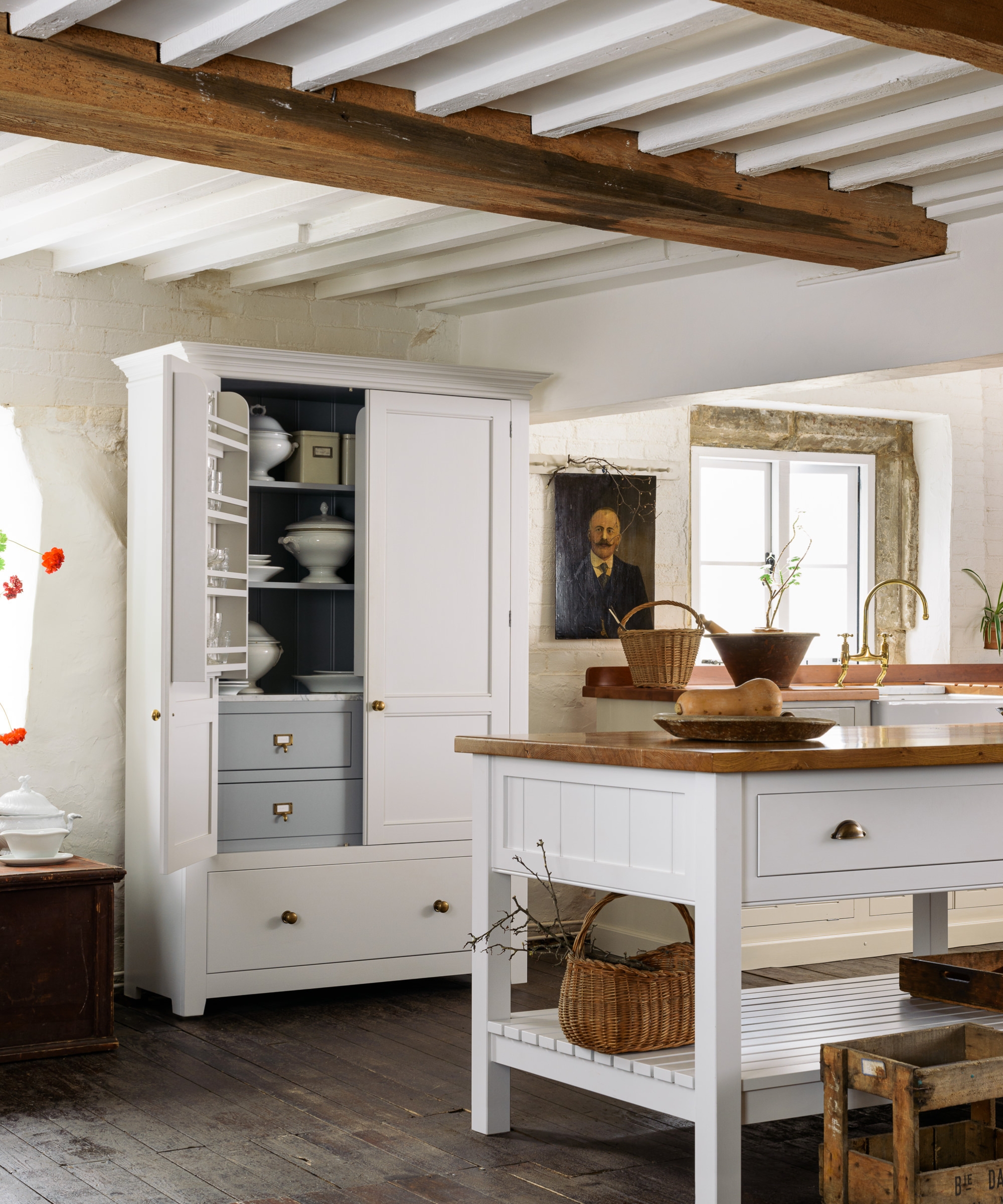 A white country kitchen with a freestaning larder