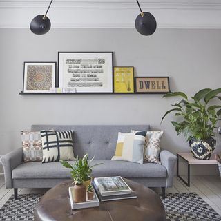 living room with grey sofa potted plants and floating shelf