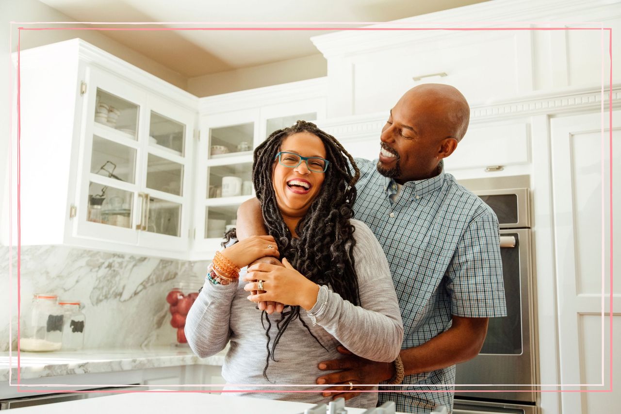 A man and woman hugging in a kitchen