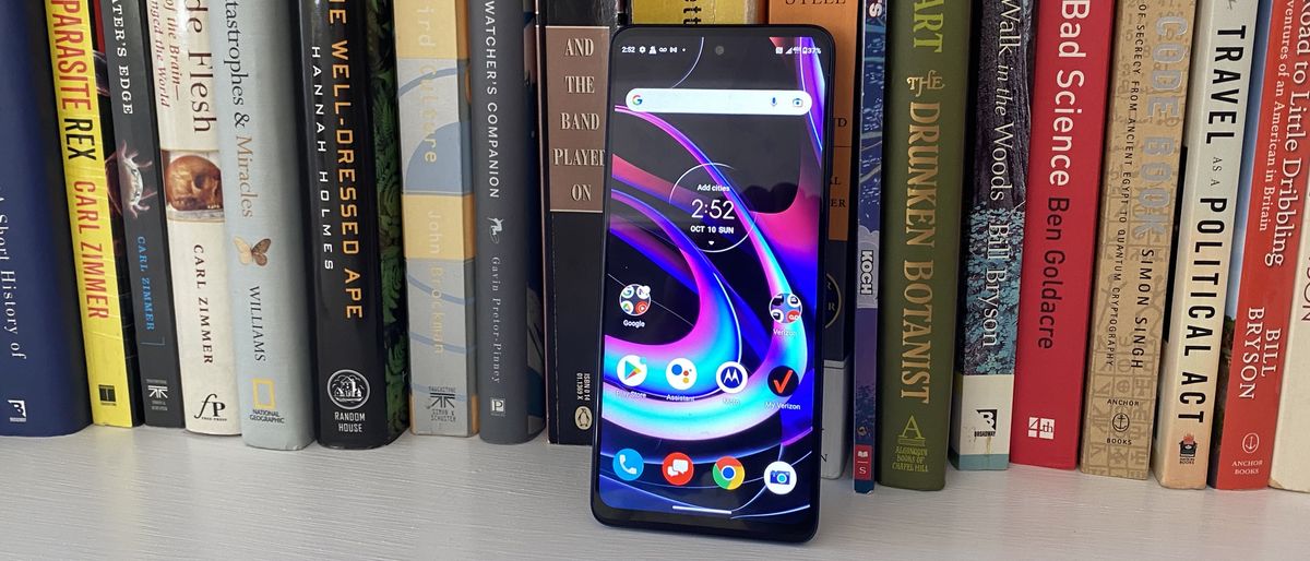 The Motorola Edge 5G UW phone in front of a bookshelf