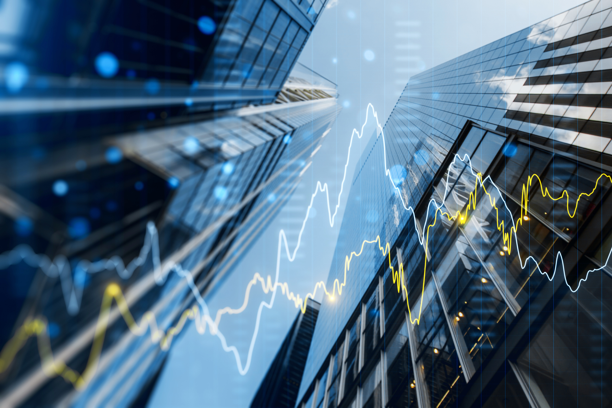 A double exposure image of skyscrapers with overlay of financial graphs 