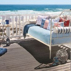 sea view with wooden flooring blue and white sofa with cushions