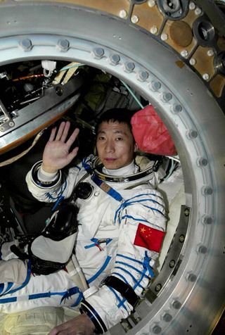 First Chinese astronaut Yang Liwei waves as the capsule door was opened after landing on the Inner Mongolian grasslands of northern China Thursday, Oct. 16, 2003.