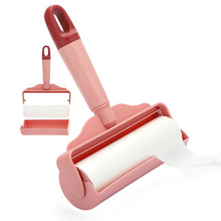 A sticky paper lint roller with a pink handle