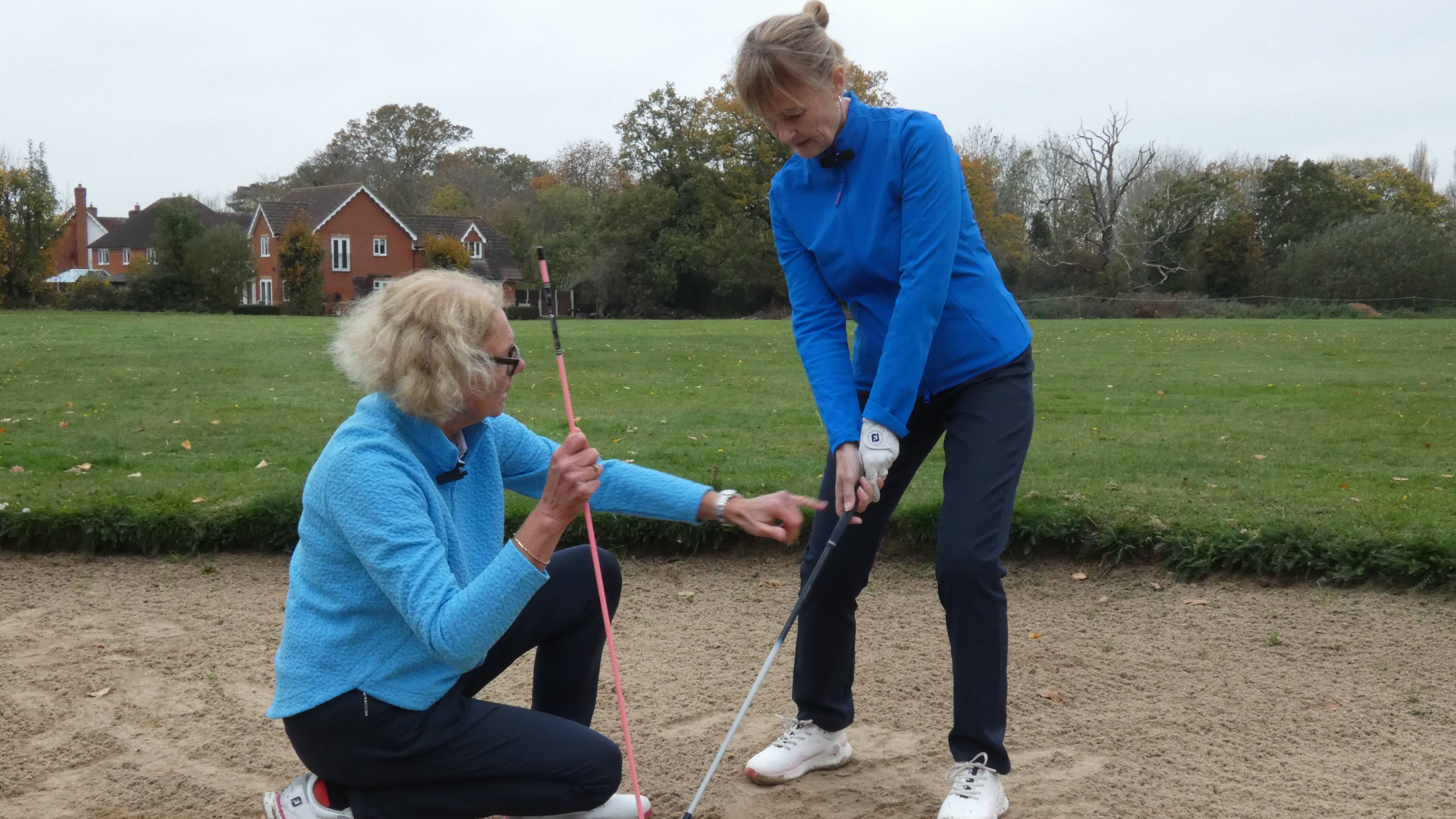 Sarah Bennett changing Alison Root&#039;s grip in a bunker