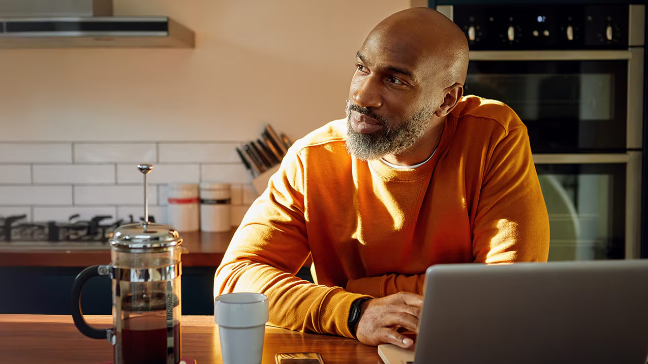 A man sitting near his laptop.