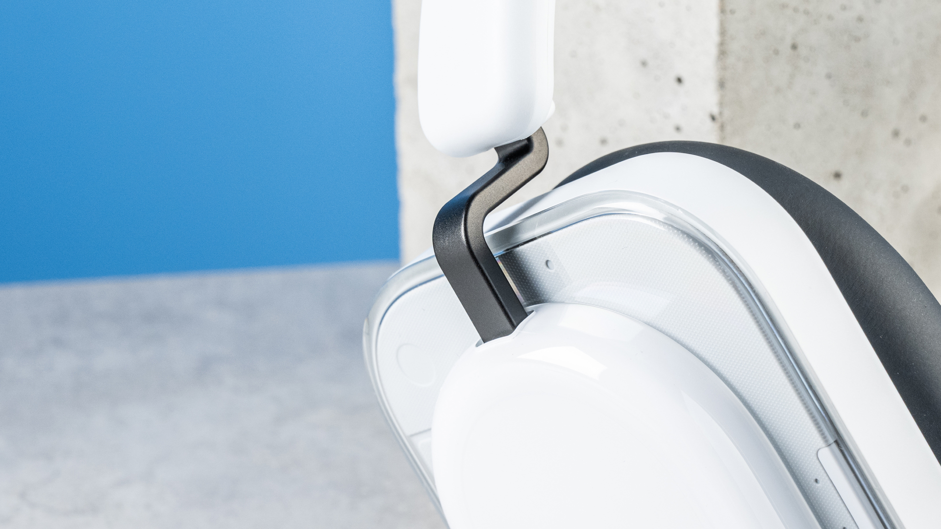 the nothing headphone (a) photographed against the blue tom's guide background, showing the transparent and white ear cups with red accents, the padded headband, and the accessories including 3.5mm jack