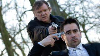 Colin Farrell as Ray holding a gun to his head and Brendan Gleeson as Ken Daley behind him during In Bruges.