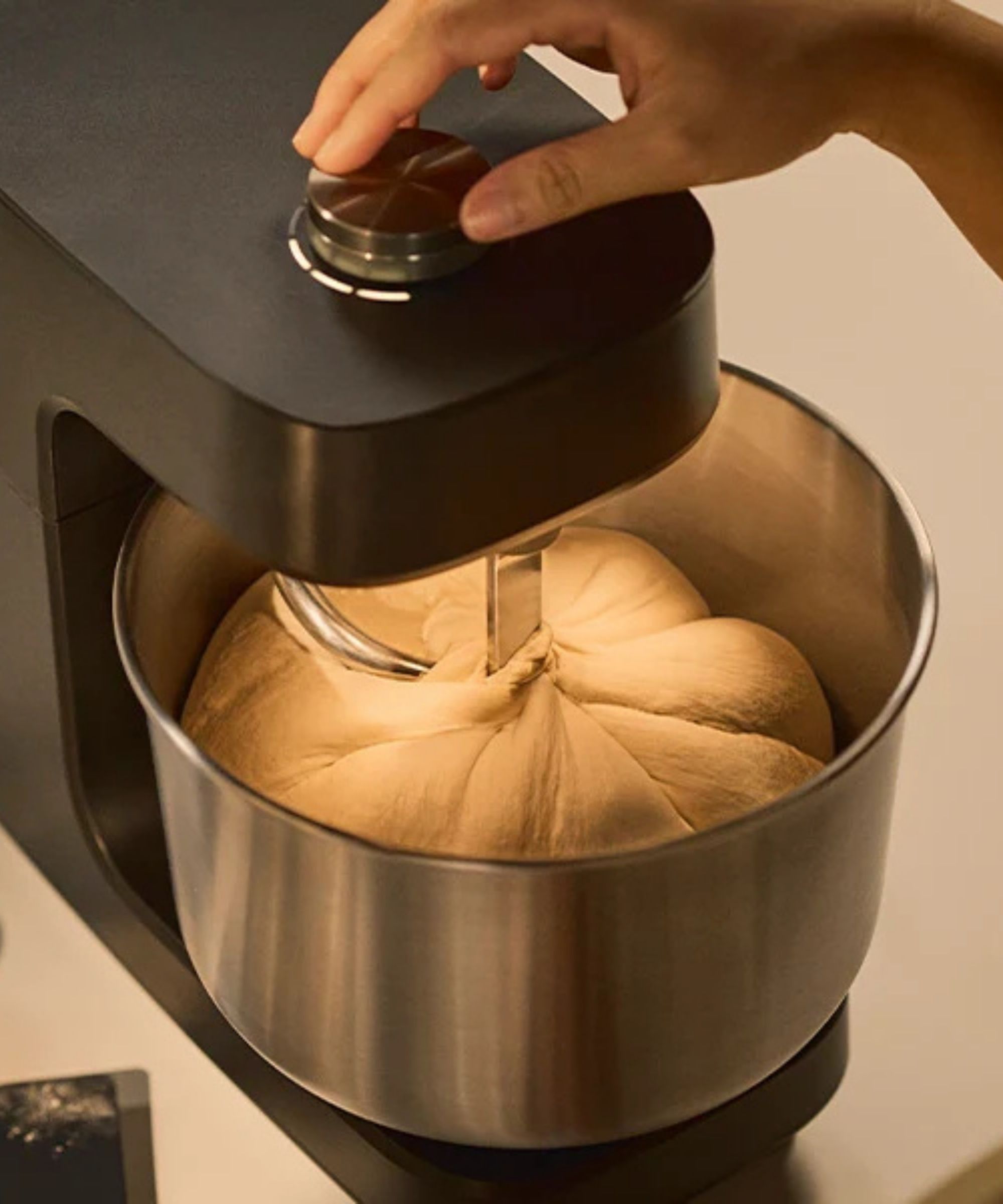 A black Ooni Halo Core Spiral Mixer with dough inside the bol.