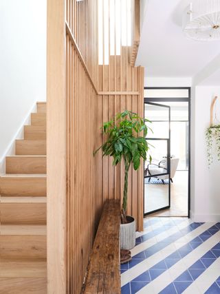staircase and entrance hall with blue chevron tiled floor and pale wood stairs and cladding and crittal style door