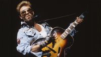 English singer and songwriter George Michael (1963-2016) performing on stage playing a semi acoustic guitar during the Japanese/Australasian leg of his Faith World Tour, February-March 1988. 