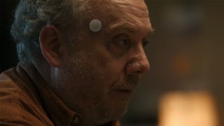 Paul Giamatti wearing a device on his temple in Black Mirror
